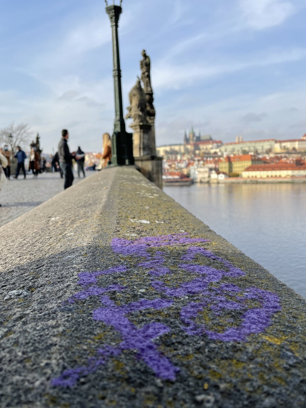 Karlův most se stal znovu terčem vandalů. Tentokrát se na něm objevil fialový nápis. (10. listopad 2021)