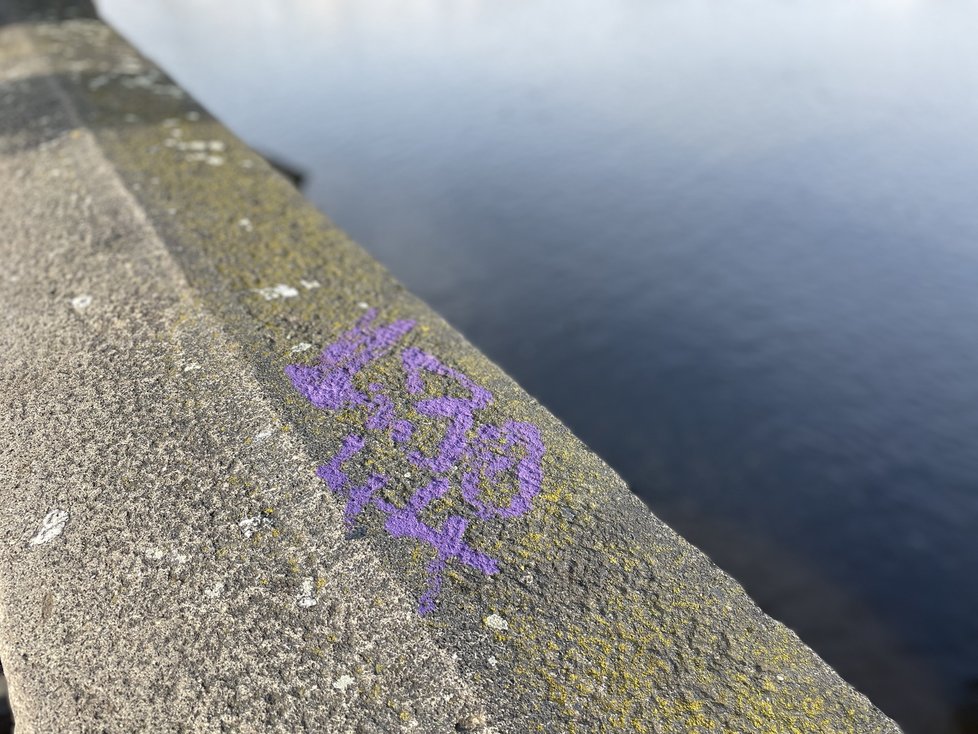 Karlův most se stal znovu terčem vandalů. Tentokrát se na něm objevil fialový nápis. (10. listopad 2021)