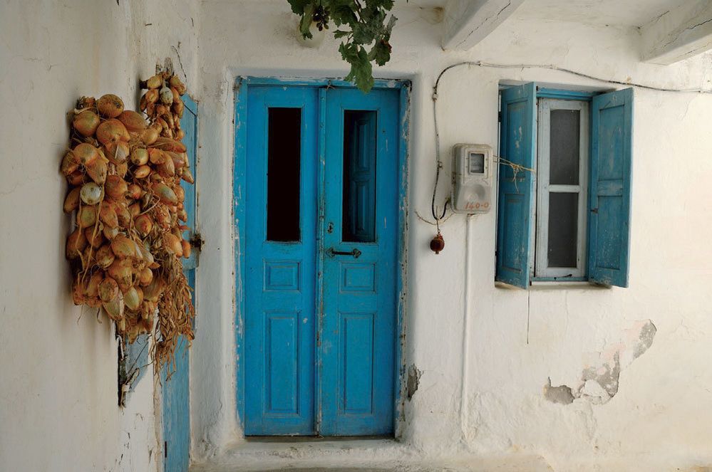 Bílé domky s modrými dveřmi či okenicem jsou symbolem Řecka.