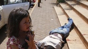Vyděšená holčička a mrtvola jednoho z civilistů, který zemřel, když se teroristé vydali do obchodního domu