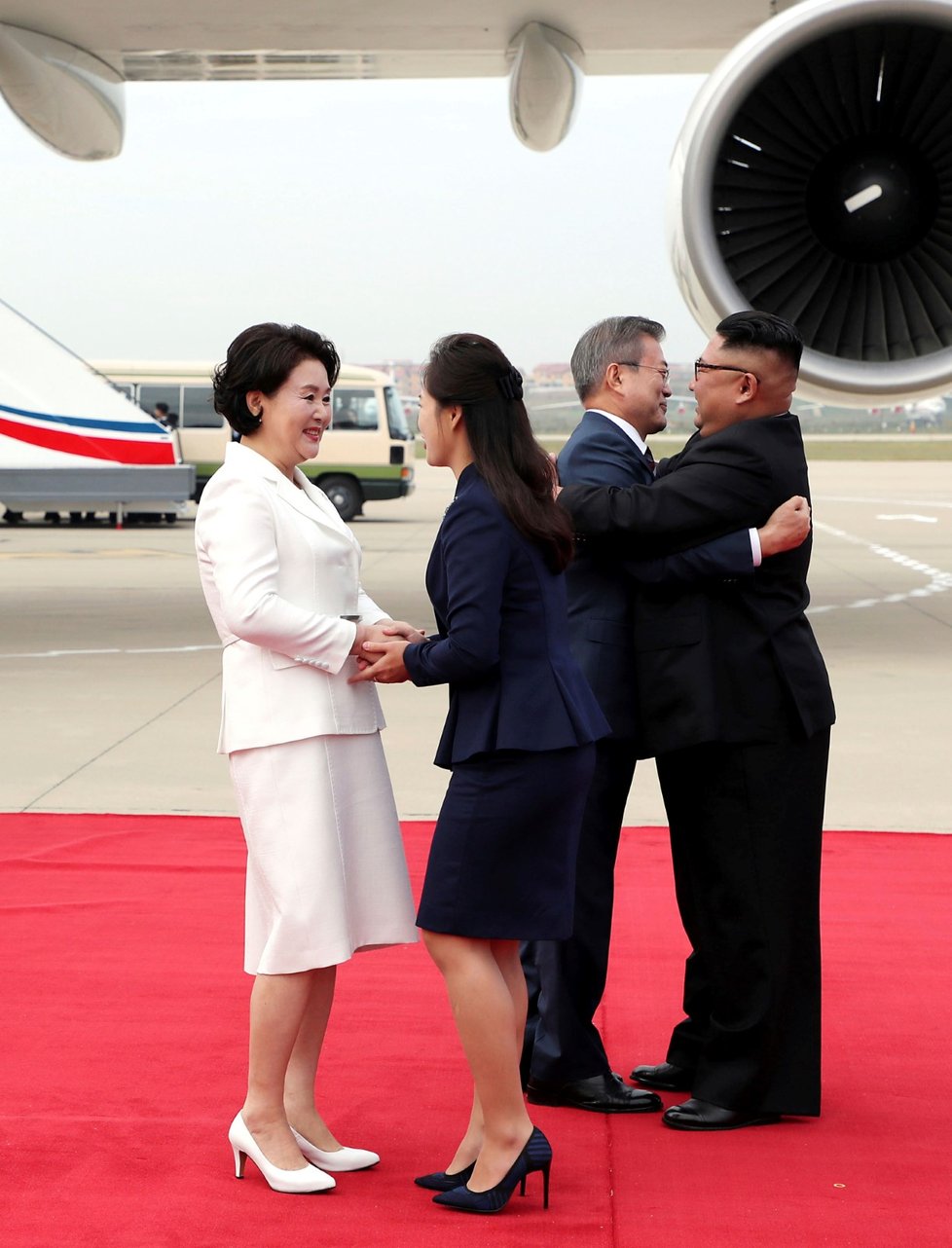 Vítání jako za Brežněva. Jihokorejský prezident Mun Če-in a severokorejský vůdce Kim čong-un si při uvítacím ceremoniálu  na letišti v Pchjongjangu padli okolo krku. Přátelsky se zdravily i obě první dámy.