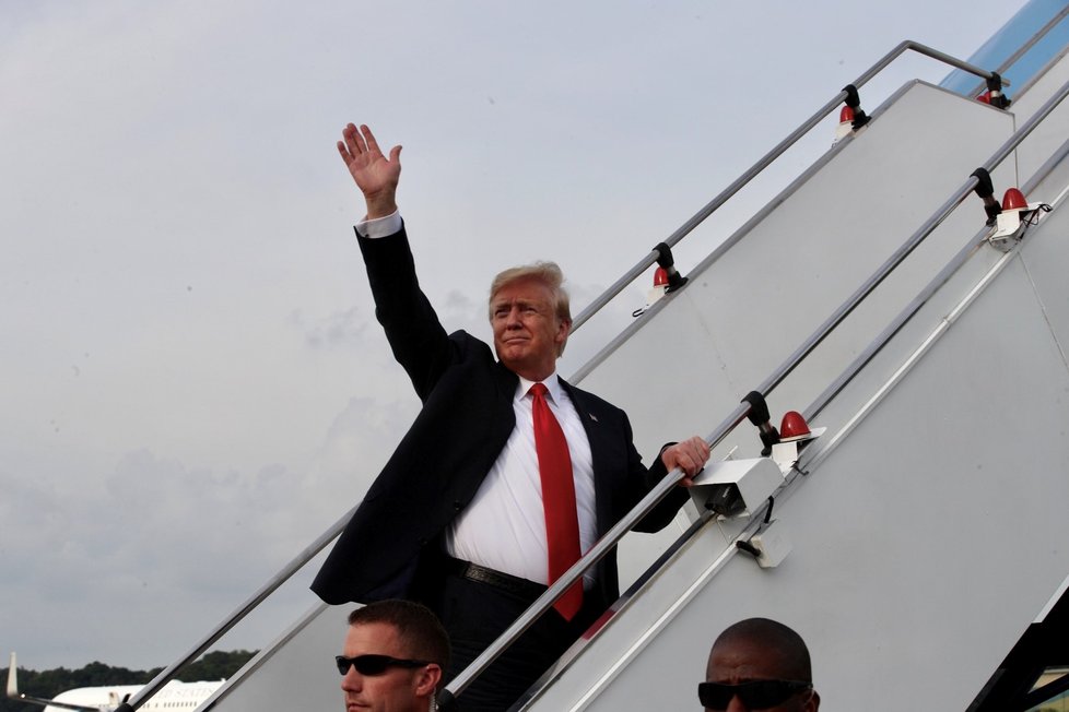 Donald Trump mává ze schodiště do letadla