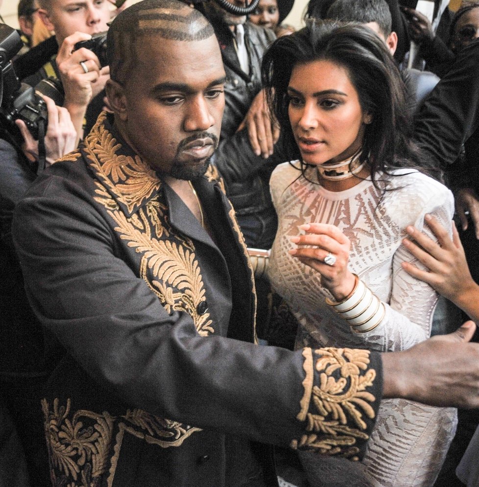 Vyděšenou Kim Kardashian odvádí její manžel Kanye West.