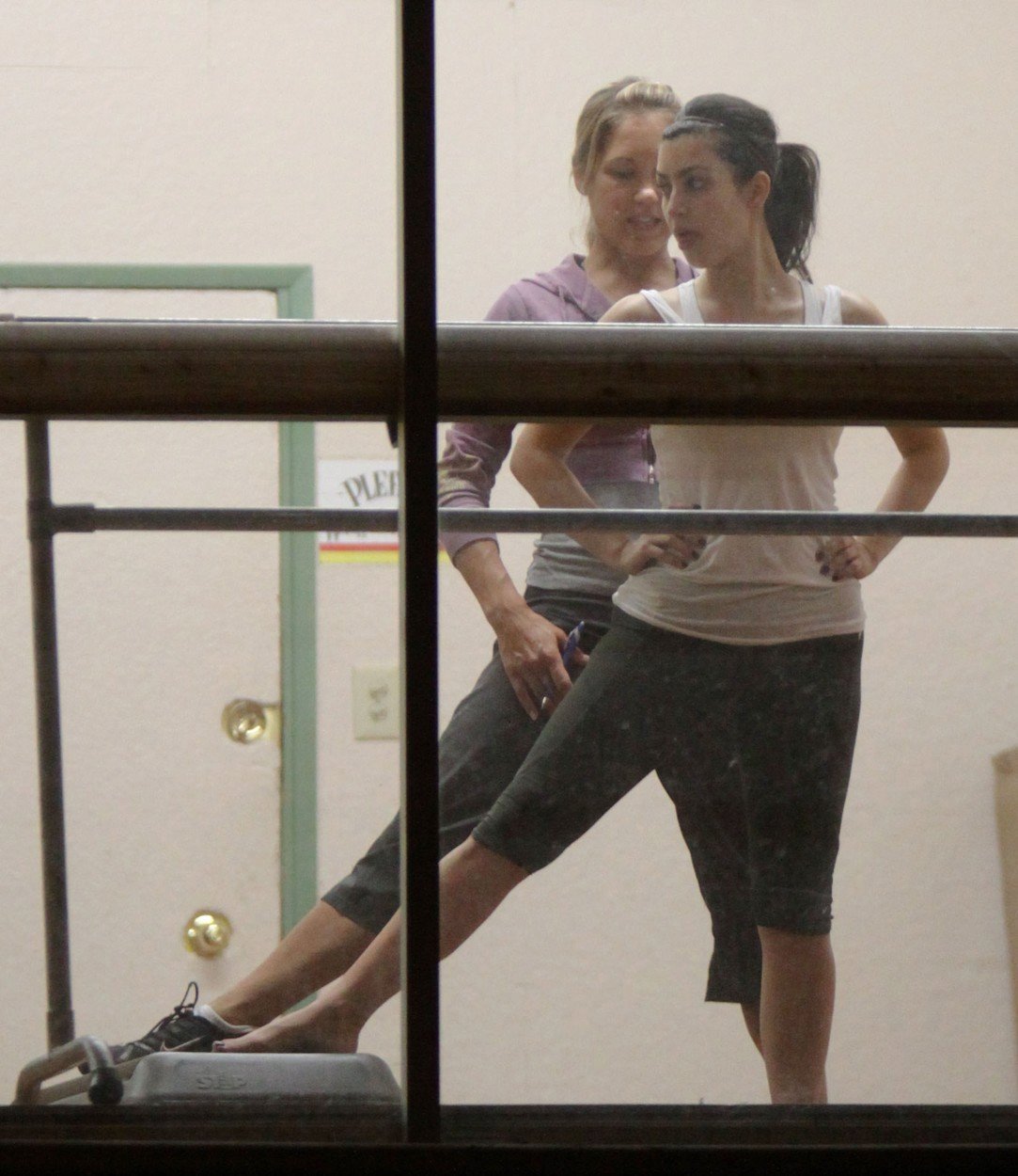 Kim Kardashian při cvičení v tanečním studiu s trenérem.