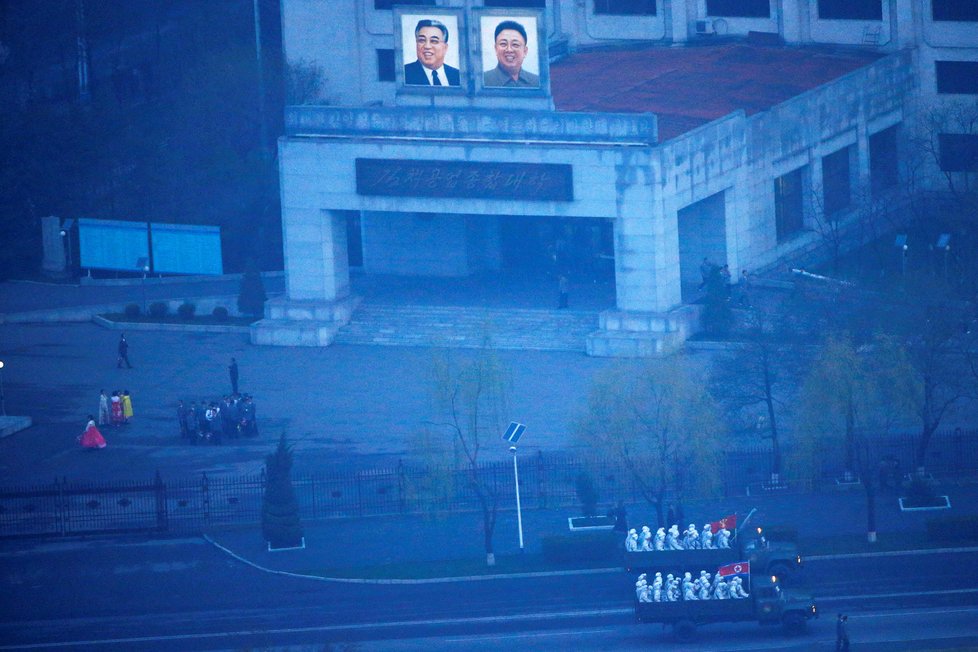 Centrem Pchjongjangu projíždějí vozy s vojáky.