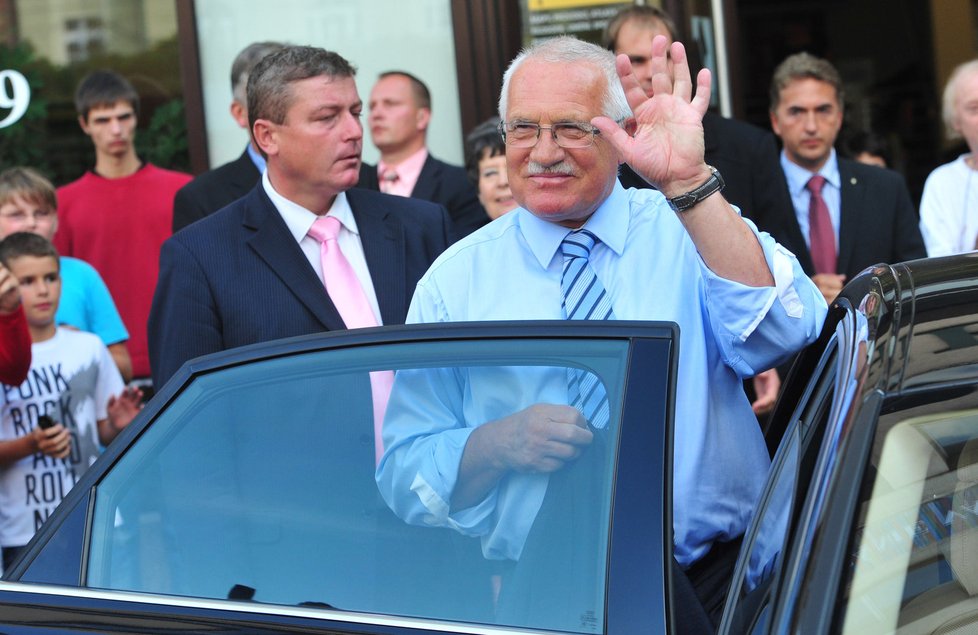 Prezident mával lidem, kteří se přišli podívat na jeho cestu do Ostravy