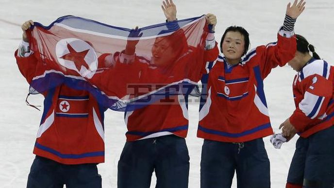 Severokorejské hokejistky s národní vlajkou po zápase se Slovinskem na turnaji v Jižní Koreji.