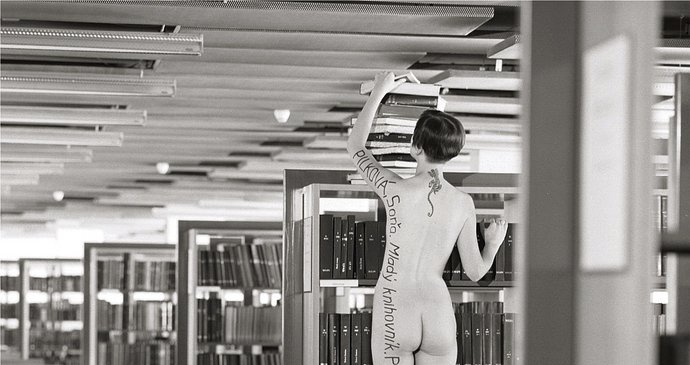 Vtipný umělecký akt nahé tetované knihovnice, popsané na levém boku od ruky přes záda až na plosku levého chodidla