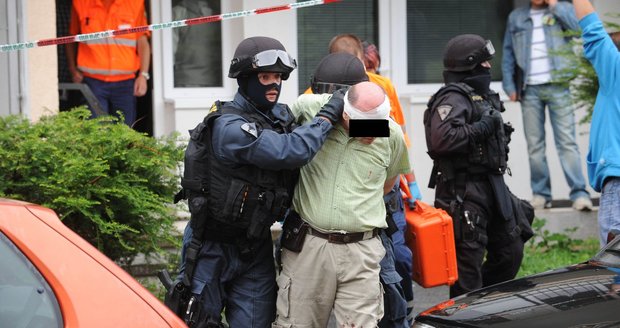 Policie vyvádí z domu útočníka