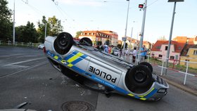 Nehoda v pražských Kobylisích: Policisté skončili s autem na střeše.