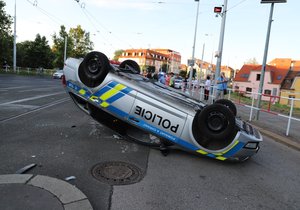 Nehoda v pražských Kobylisích: Policisté skončili s autem na střeše.