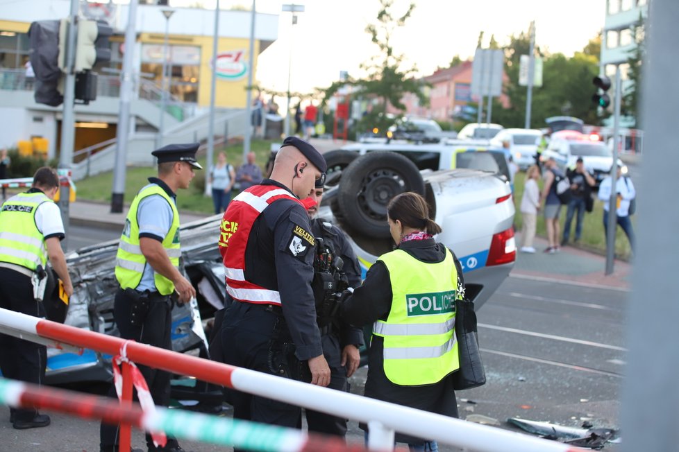 Nehoda v pražských Kobylisích: Policisté skončili s autem na střeše.