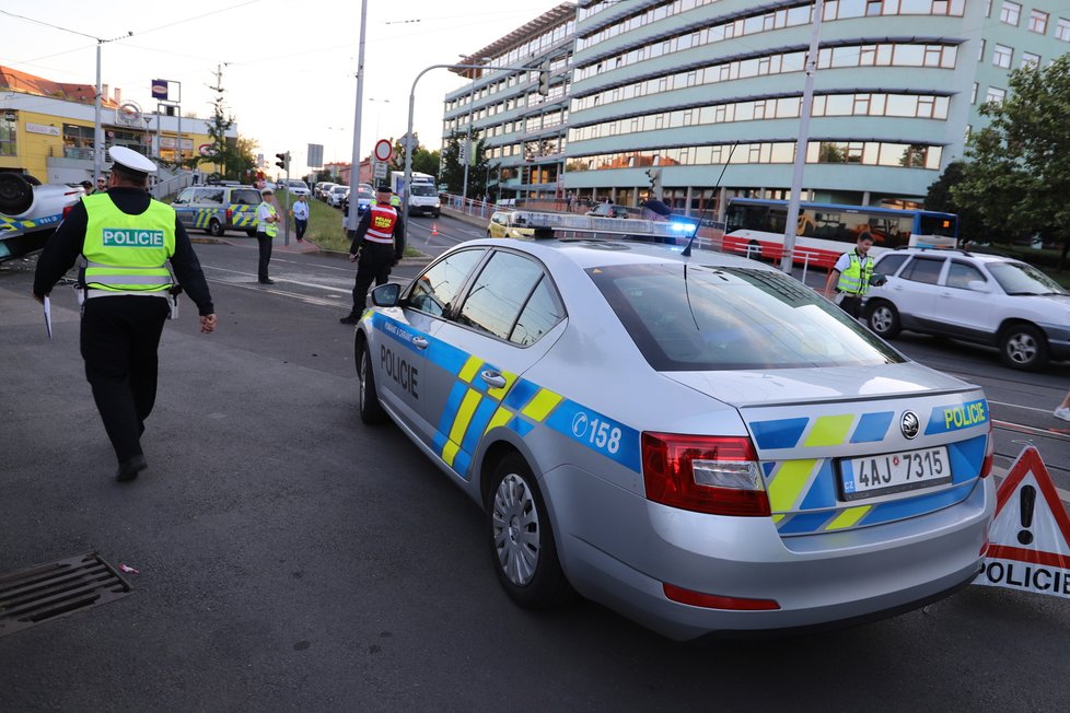 Nehoda v pražských Kobylisích: Policisté skončili s autem na střeše.