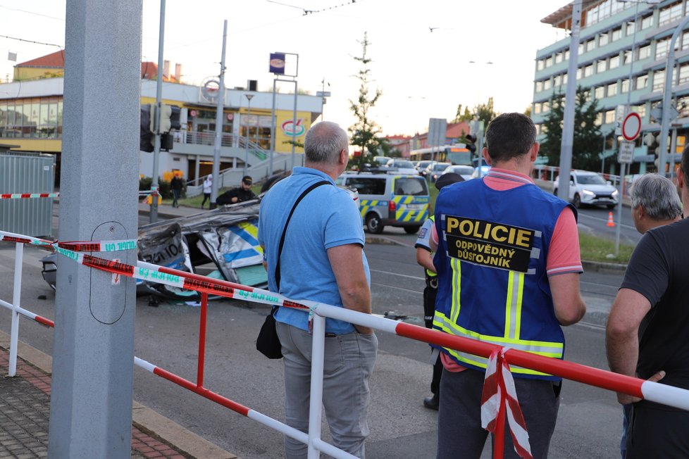 Nehoda v pražských Kobylisích: Policisté skončili s autem na střeše.