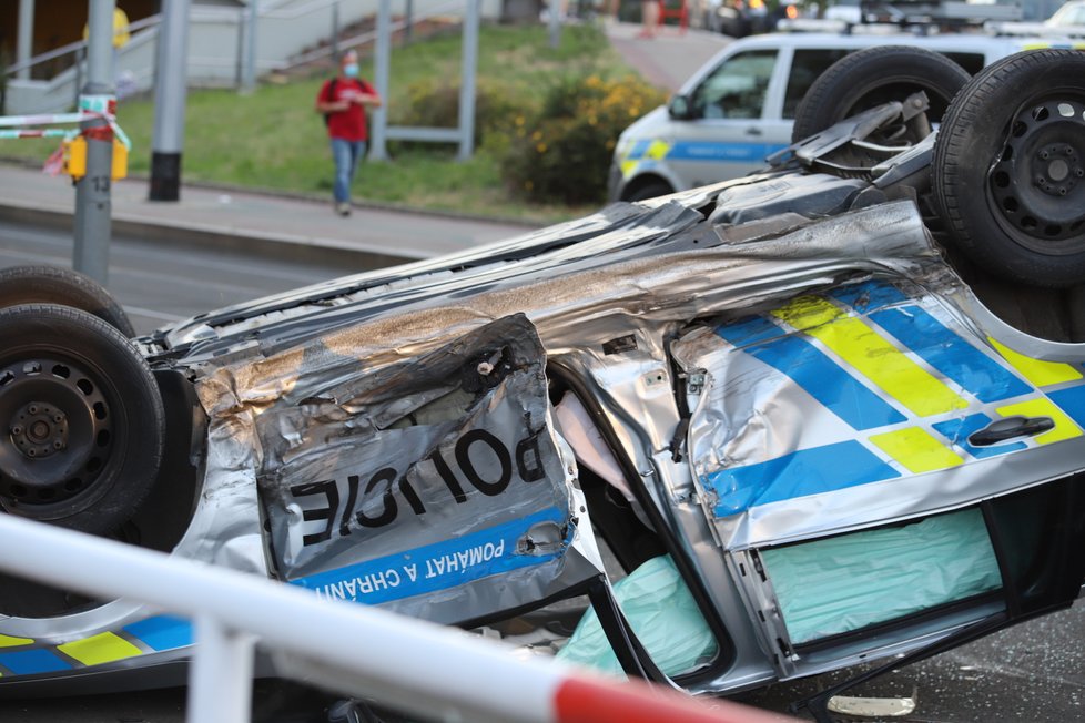 Nehoda v pražských Kobylisích: Policisté skončili s autem na střeše.