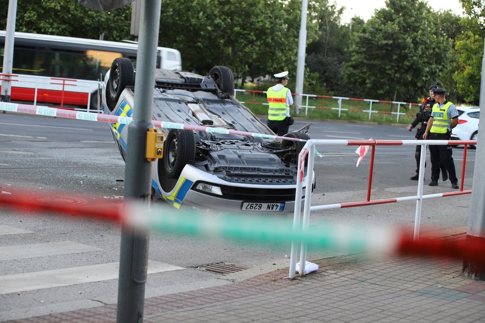 Nehoda v pražských Kobylisích: Policisté skončili s autem na střeše.