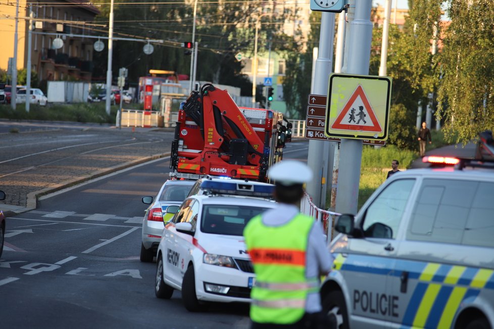 Nehoda v pražských Kobylisích: Policisté skončili s autem na střeše.