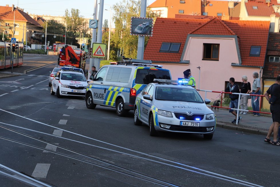 Nehoda v pražských Kobylisích: Policisté skončili s autem na střeše.