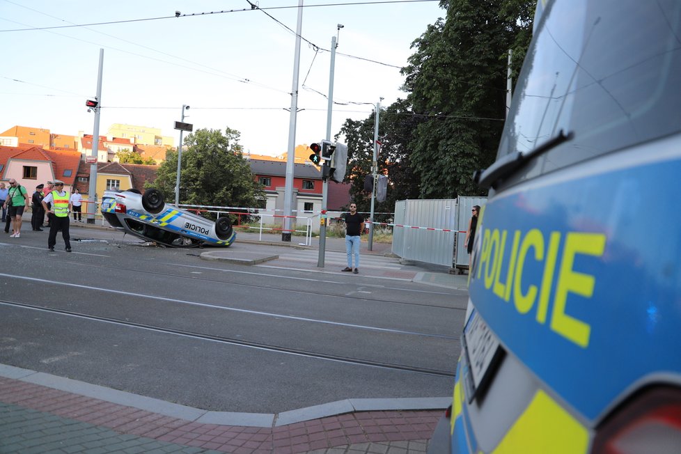 Nehoda v pražských Kobylisích: Policisté skončili s autem na střeše.