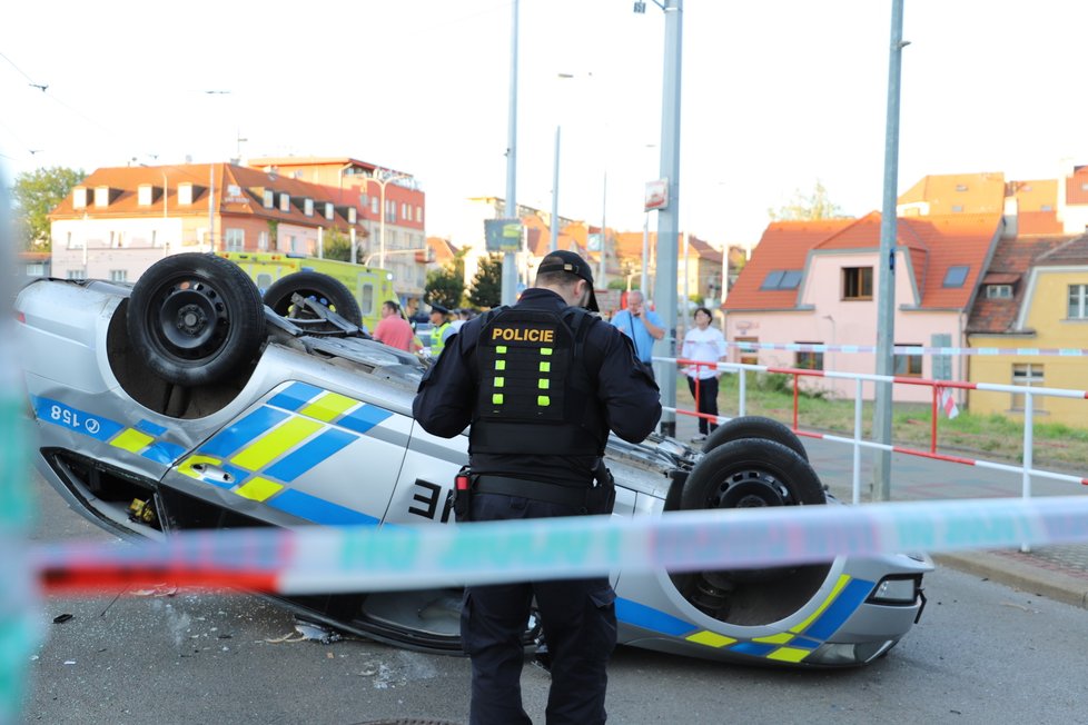 Nehoda v pražských Kobylisích: Policisté skončili s autem na střeše.