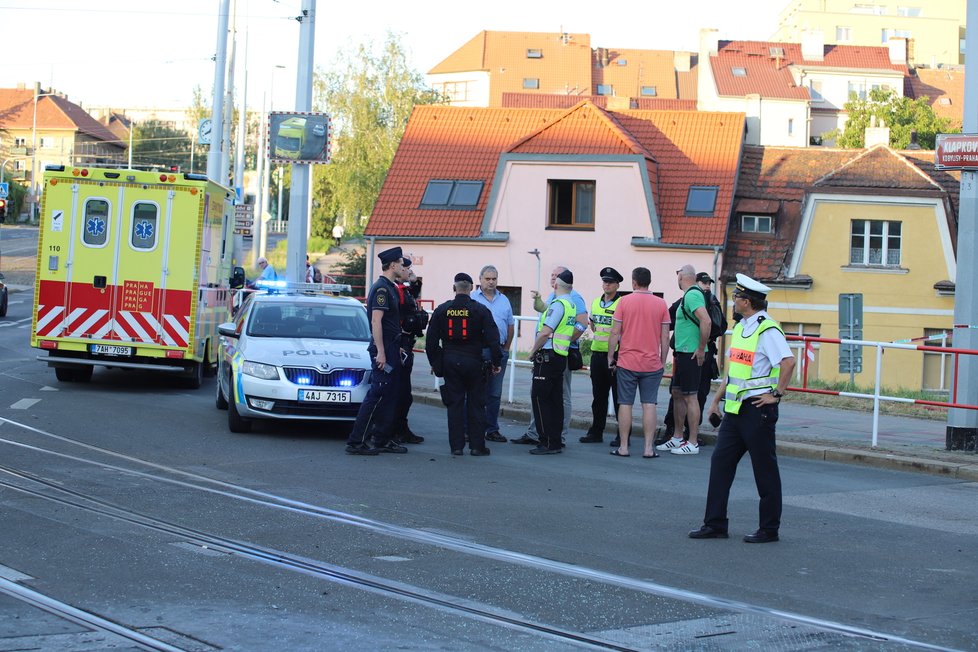 Nehoda v pražských Kobylisích: Policisté skončili s autem na střeše.