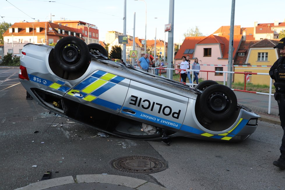 Nehoda v pražských Kobylisích: Policisté skončili s autem na střeše.