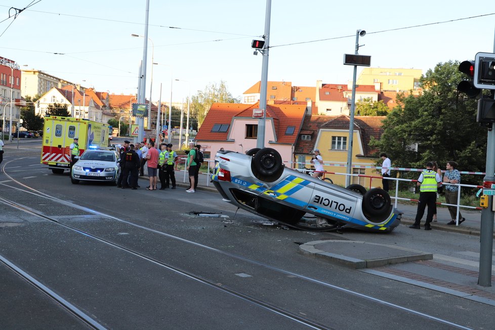 Nehoda v pražských Kobylisích: Policisté skončili s autem na střeše.