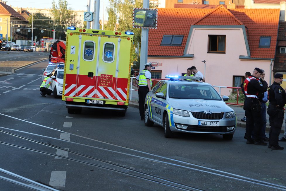 Nehoda v pražských Kobylisích: Policisté skončili s autem na střeše.