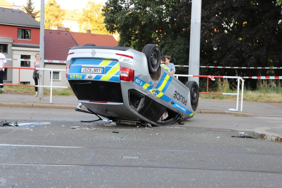 Nehoda v pražských Kobylisích: Policisté skončili s autem na střeše.