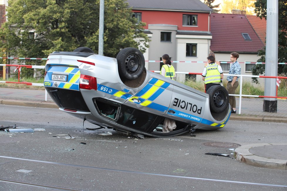 Nehoda v pražských Kobylisích: Policisté skončili s autem na střeše.