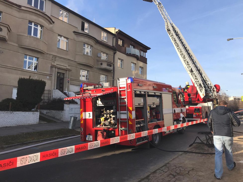 Plameny zachvátily půdní byt v Kobylisích, 25. února 2019.