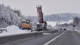 Dělníci odklízejí 16. prosince 2018 sníh na 96. kilometru v opravovaném úseku dálnice D1 s uzavřenými levými pruhy mezi Humpolcem a Větrným Jeníkovem. Ředitelství silnic a dálnic (ŘSD) poslalo firmě Geosan Group příkaz rozšířit jízdní pruhy (16.12.2018)