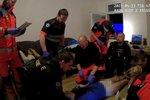Záchranáři a policisté oživují muže, který zkolaboval při hraní počítačové hry.