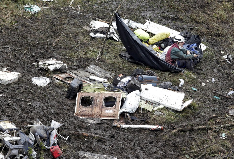 Záchranáři vyprošťují z trosek havarovaného letadla lidská těla.