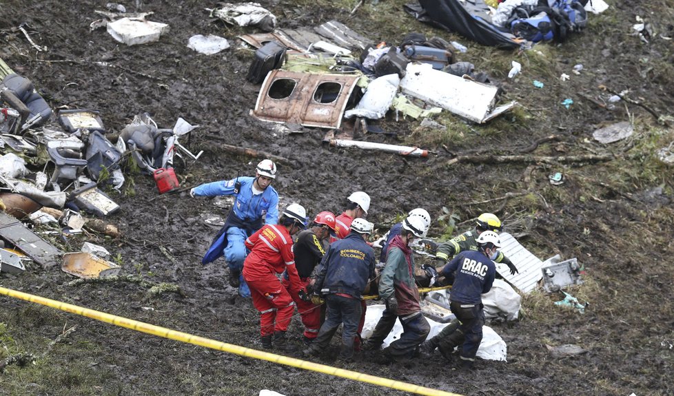 Záchranáři vyprošťují z trosek havarovaného letadla lidská těla.