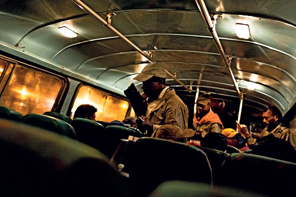 Starý americký autobus veze muže na jejich pravidelnou šichtu