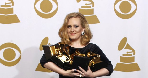 Adele a jeden z jejích striktně černých gala outfitů. Tento se skládal ze sametového topu a dlouhé krinolínové sukně. Naštěstí mosaz sklizených gramofonů temný monolit oživila. Znáte snad velkolepější šperk?