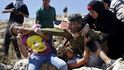 Palestinci se snaží izraelskému vojákovi zabránit v zadržování chlapce během protestu proti židovským osadám. Stalo se poblíž Ramalláhu na izraelském Západním břehu Jordánu, na palestinských územích, 28. srpna 2015.