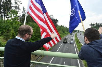 Na mostě přes dálnici u Ejpovic lidé konvoj vítali americkými vlajkami.