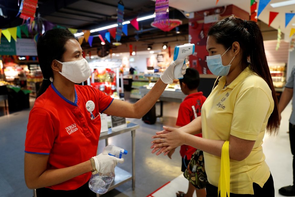 Přísný režim je i v hlavním městě Thajska, Bangkoku.Zaměstnanci s ochrannými obličejovými maskami kontrolují teplotu zákazníkům při vstupu do supermarketu kvůli šíření koronaviru.(30. 3. 2020)