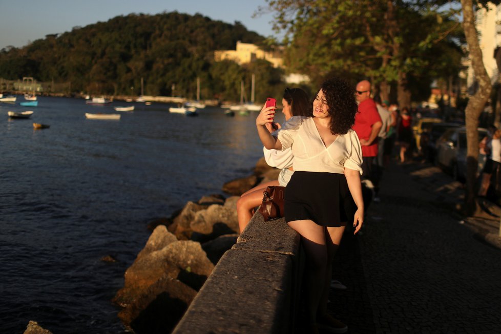Koronavirus v Brazílii: Obyvatelé Ria se vyšli podívat na nádherný západ slunce, roušky sundavali hlavně kvůli selfie fotkám.