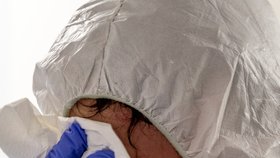 Zdravotník si otírá obličej po péči o pacienty s koronavirem, pro něž má Podřipská nemocnice s poliklinikou v Roudnici nad Labem vyčleněných 20 standardních lůžek (11. 3. 2021)