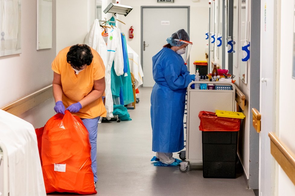 Personál pracuje na chodbě oddělení, kde pečují o pacienty s koronavirem, pro něž má Podřipská nemocnice s poliklinikou v Roudnici nad Labem vyčleněných 20 standardních lůžek (11. 3. 2021).