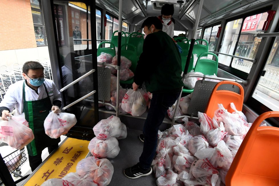 Lidé nakládají autobus potravinami, které pošlou do Wu-chanu, zdroje nového koronaviru (1. 3. 2020).