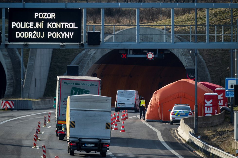 Kamion projíždí kolem kontrolního stanoviště na příjezdu z Německa na dálnici D8 před tunely Panenská u Petrovic na Ústecku poblíž česko-německého hraničního přechodu Petrovice/Lückendorf, jehož provoz byl 16. března 2020 omezen kvůli hrozbě koronaviru (16. 3. 2020).