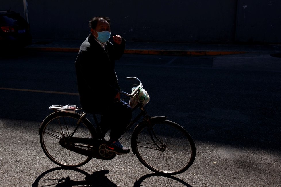 Muž na kole v roušce v Pekingu (3.3.2020)