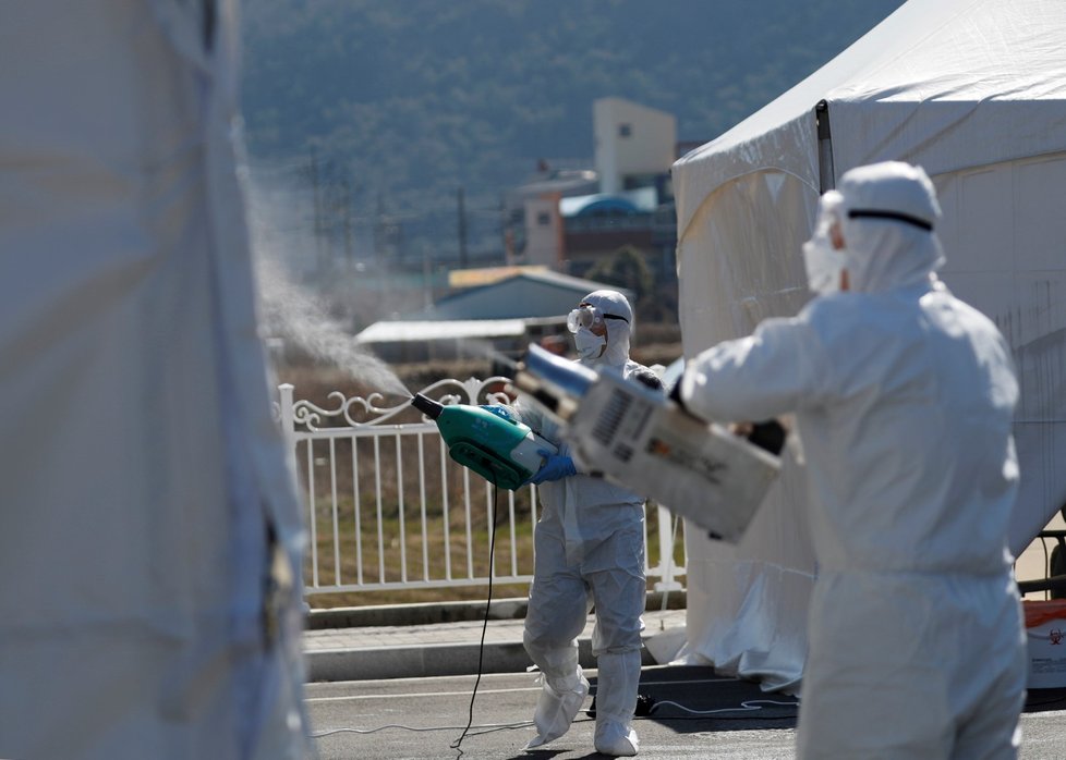 Pracovníci dezinfikují zařízení pro testování na koronavirus v jihokorejském okrese Cheongdo (11.3.2020)