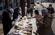 Lidé nakupují jídlo v ochranných maskách v ulicích Pekingu