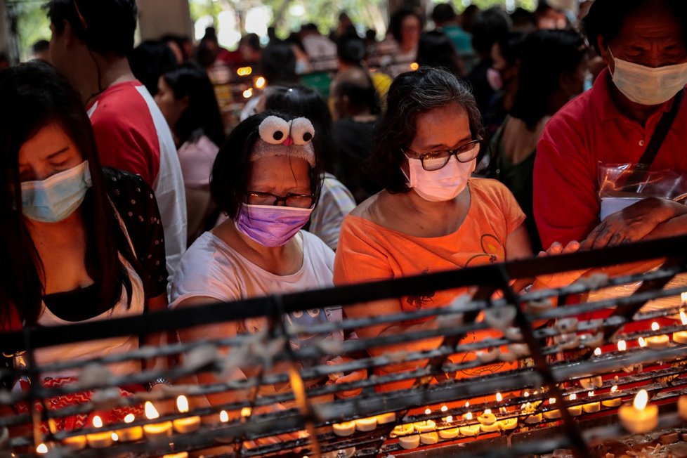 Lidé v ochranných rouškách se modlili nad zapálenými svíčkami u oltáře Matky ustavičné pomoci