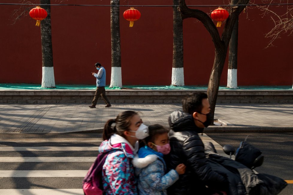 Lidé v rouškách v ulicích Pekingu